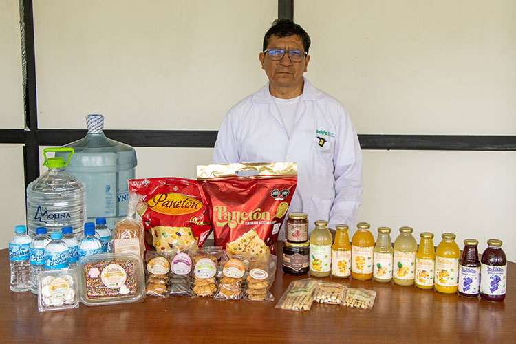 Exhibición de la línea INDDA 2026: panetón, galletas, néctares de frutas y agua de mesa presentados por un especialista de la UNALM