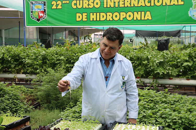 Especialista de la UNALM muestra las raíces de una plántula de hortaliza durante una sesión práctica del Curso Internacional de Hidroponía