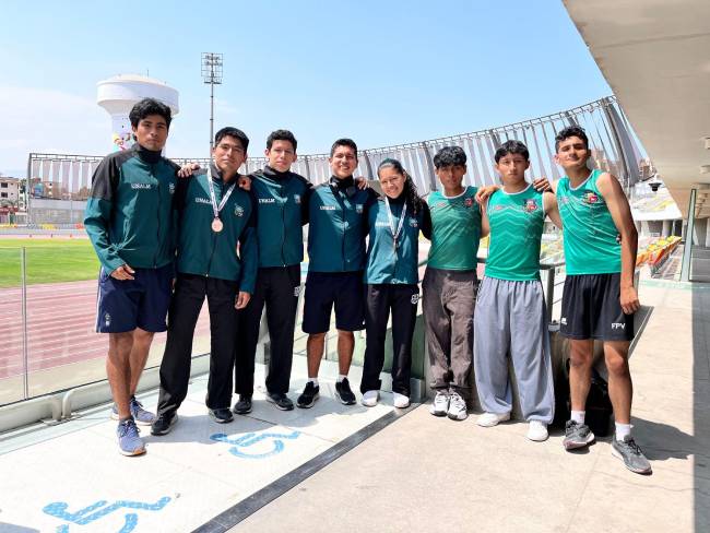 Delegación UNALM de atletismo posa en grupo en la VIDENA; dos integrantes lucen medallas de bronce del Campeonato Nacional Universitario 2026