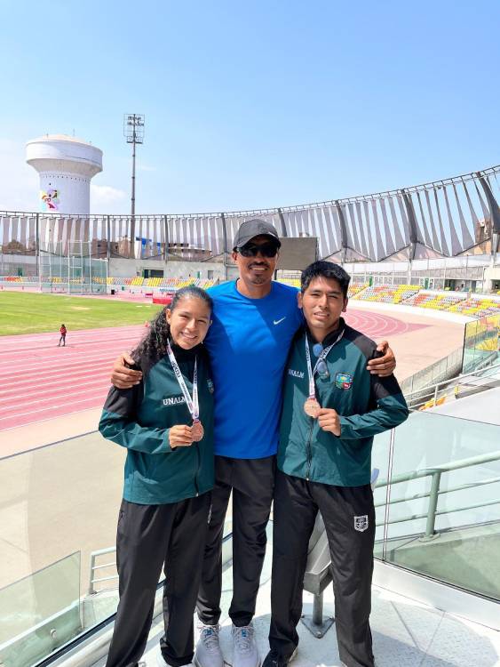 Kurmi Solís y Anthony Gómez muestran sus medallas de bronce junto a su entrenador en la pista atlética de la VIDENA, San Luis